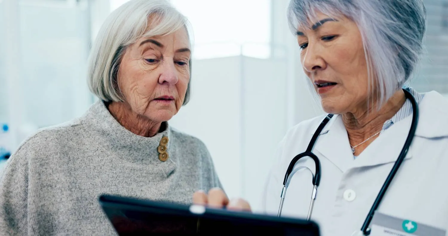 An older woman looking over a chart with her doctor
